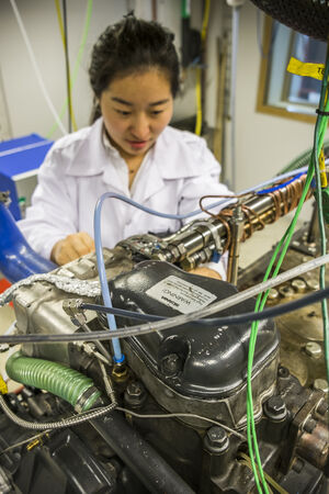 PhD-student working on a motor. Photo.