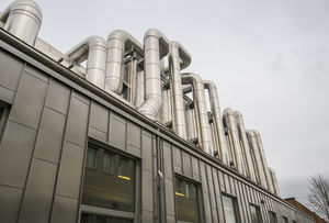 Building with aluminium pipes on the roof. Photo.